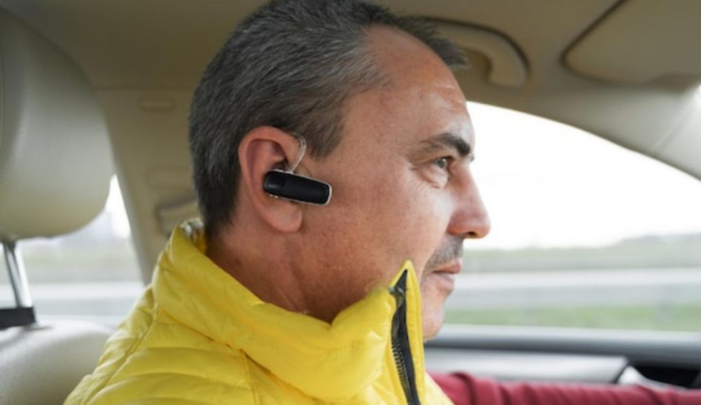 Uomo con auricolari al volante