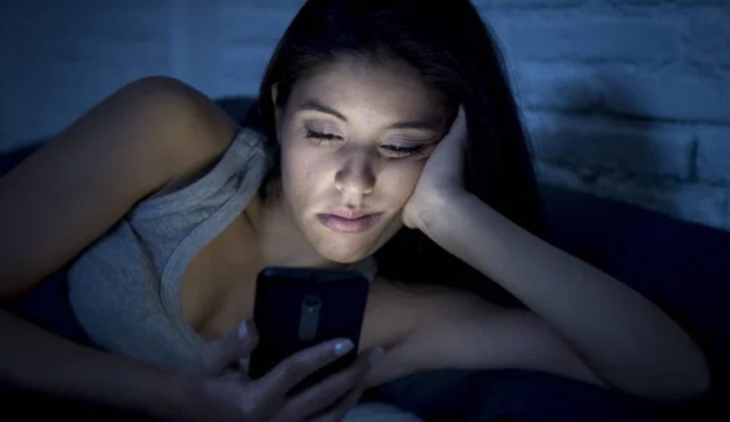 Donna a letto con il cellulare (Depositphotos foto) - www.energycue.it