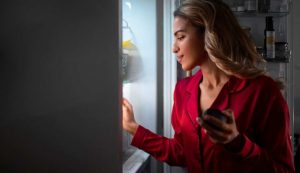 Donna che apre il frigo